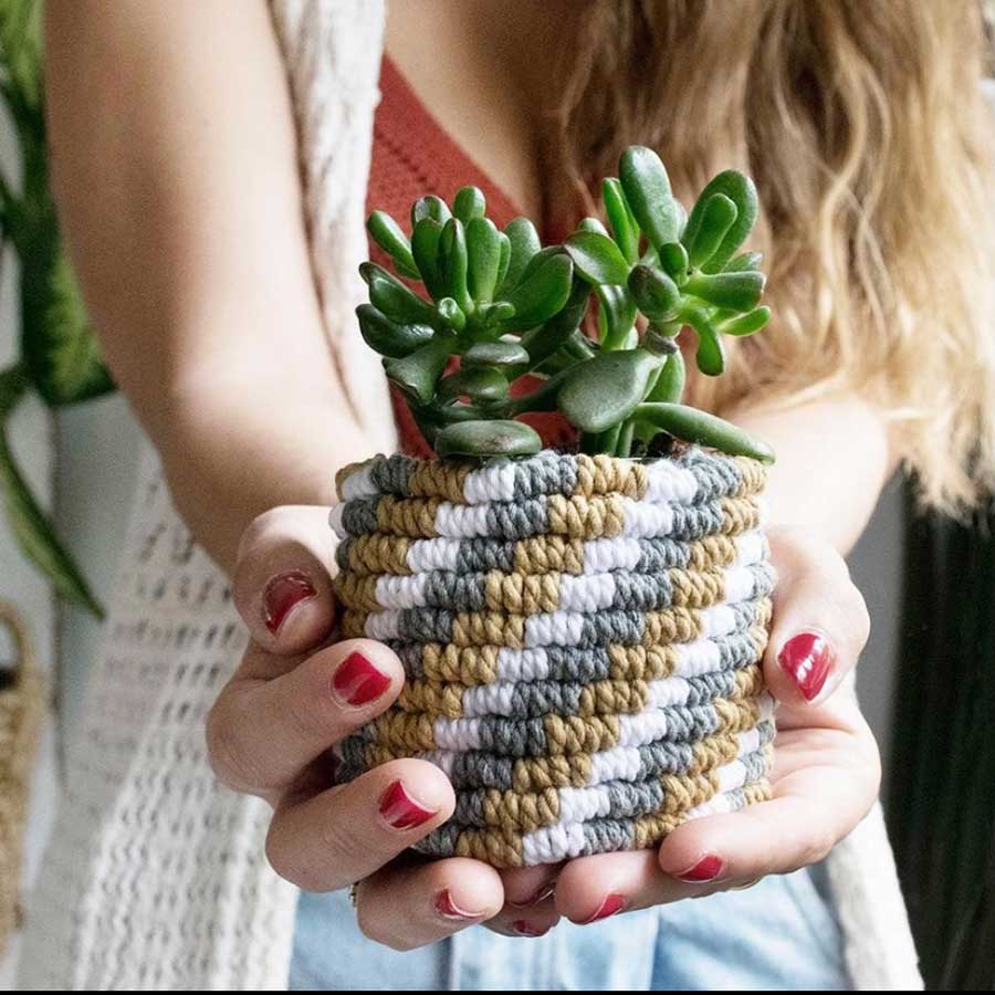 Chica sujetando cesto macramé